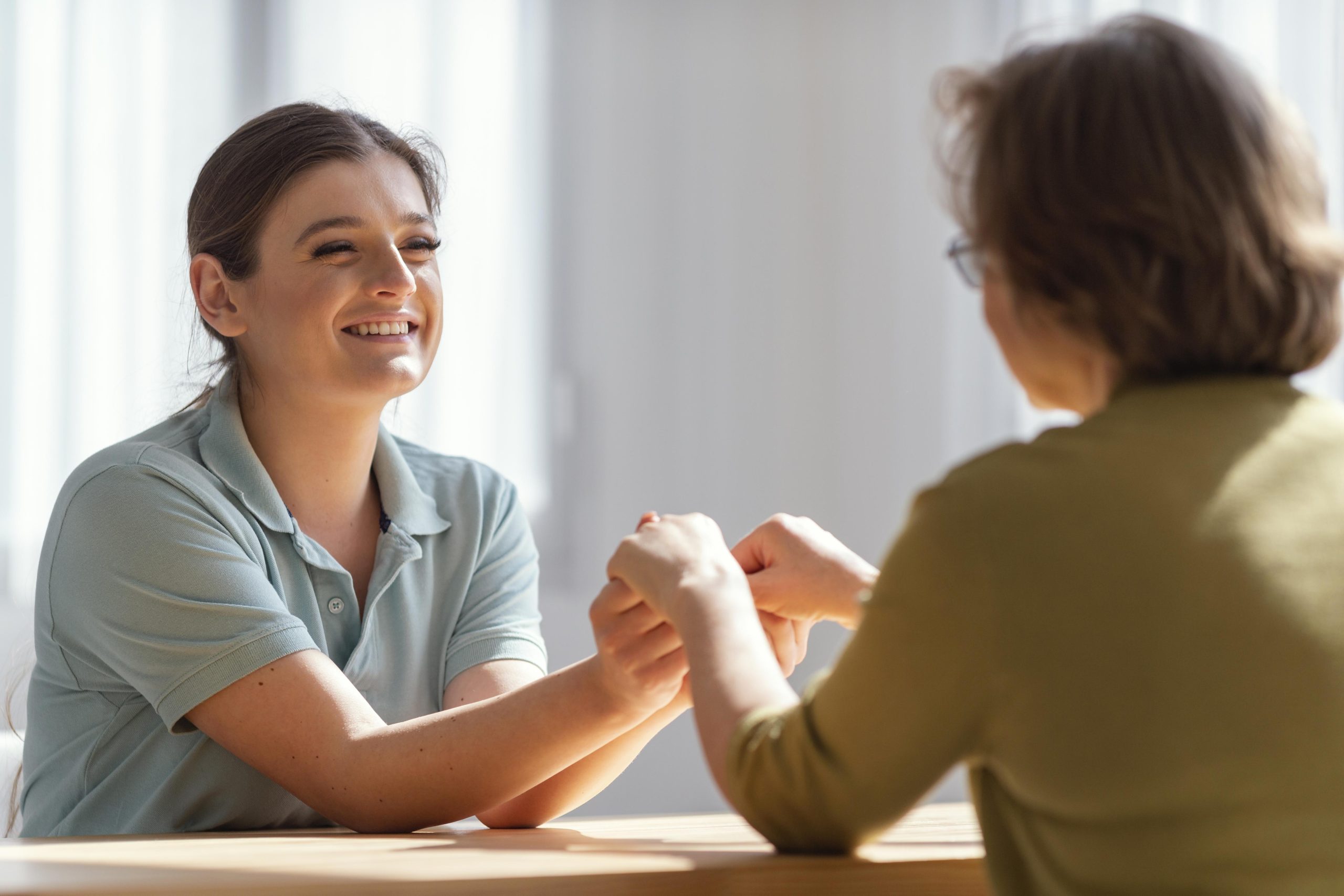 medium-shot-women-holding-hands-indoors